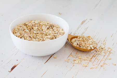 Oat meal in white bowl, wood background, copy spaceの写真素材