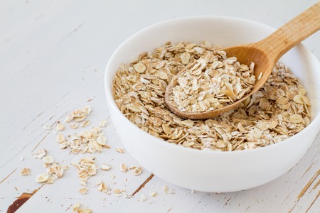 Oat meal in white bowl, wood background, copy spaceの写真素材
