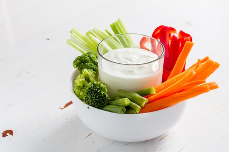 Vegetable sticks and yogurt dip, white wood backgroundの写真素材