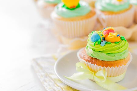 Easter cupcakes on white wood background, closeup