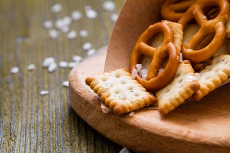 Selection of salty snacks, wood background, closeupの写真素材