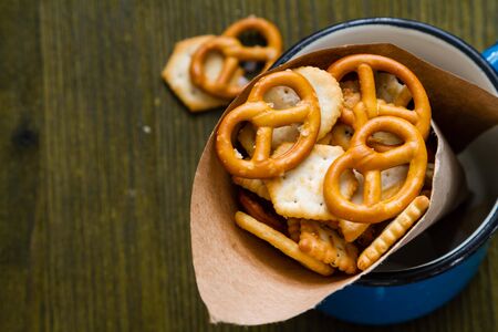 Selection of salty snacks, wood background, top viewの写真素材