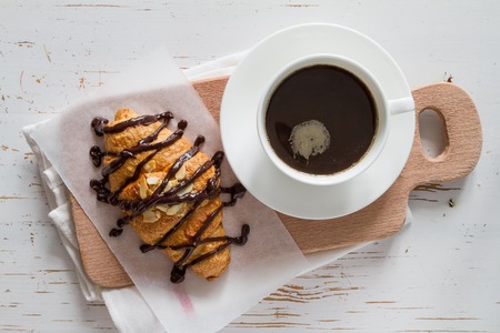 Croissantswith almonds and chocolate, coffee on wood backgroundの写真素材