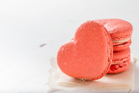 Heart shaped macaroon on white wood background, copy spaceの写真素材