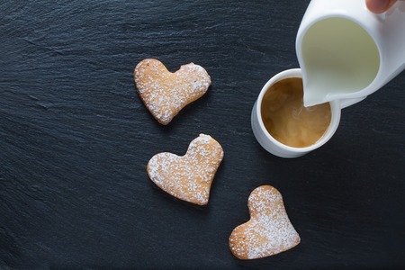 Coffee and heart shaped cookies, dark stone background, copy spaceの写真素材