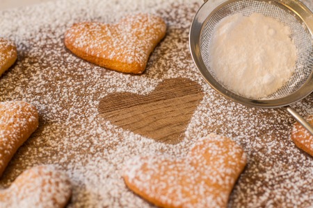 Heart shaped cookies on wood background, sugar powderの写真素材