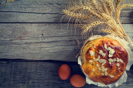 Easter bread and ingredients on rustic wood background, copy space