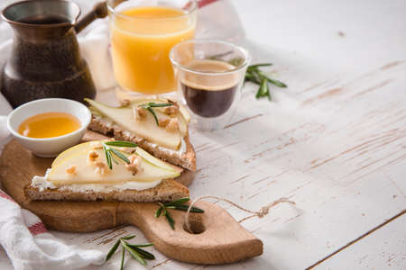Toasts with pear, goat cheese and walnuts honey rosemary, copy space, tonedの写真素材