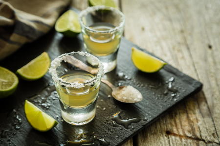 Gold tequila shots on rustic wood background, copy spaceの写真素材