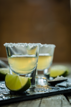 Gold tequila shots on rustic wood background, copy spaceの写真素材