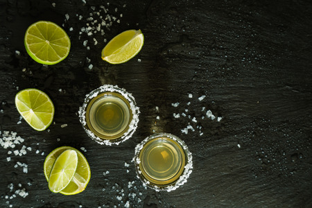 Gold tequila shots on rustic wood background, copy spaceの写真素材