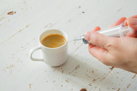 Health care concept - coffee beans in plastic syringe, white background, copy spaceの写真素材