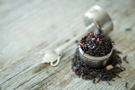 Dry black tea in infuser, copy space