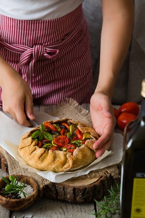 Making ratatouille galette pie, hands on rustic backgroundの写真素材