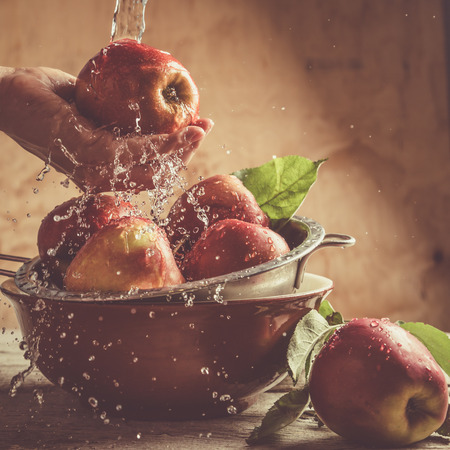 Washing apples with water splashes, hand, copy space, tonedの写真素材