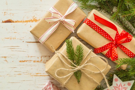 Christmas presents in decorative boxes, white wood background