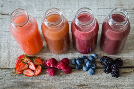 Selection of berry smoothies on rustic wood background, copy spaceの写真素材
