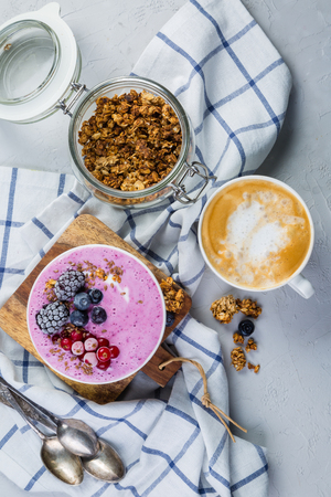 Breakfast - yogurt bowl with granola and berries, coffee, honeyの写真素材