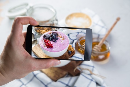 Taking photos of breakfast to phoneの写真素材