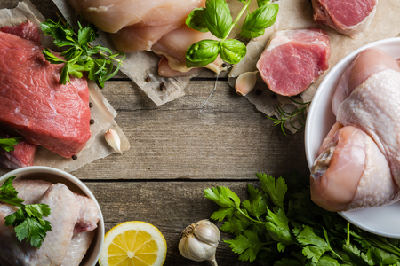 Selection of different meat cuts on rustic wood backgroundの写真素材