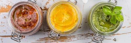 Selection of colorful hummus in jarsの写真素材