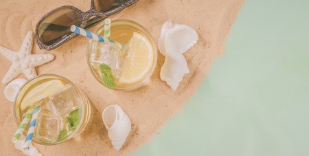 Summer concept - sand, drinks, glasses, shellsの写真素材