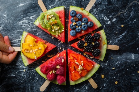 Watermelon pizza - slices with berries and fruits, granola. Fresh low carb diet