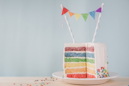 Birthday background - striped rainbow cake with white frostingの写真素材