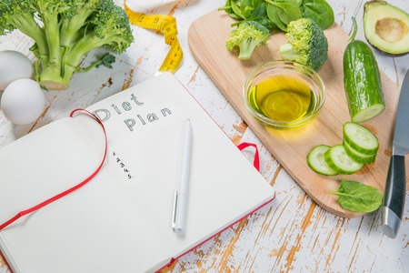 Diet plan concept - selection of green food and note padの写真素材