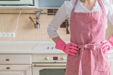 Cleaning concept - female holding cleaning supplies in blue basketの写真素材