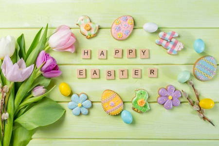Easter concept - cookies with flowers on green wood backgroundの写真素材