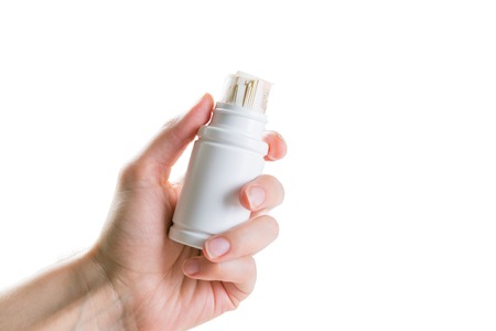 Overpriced drugs concept - hand holding drug container with euro billsの写真素材