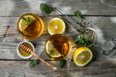 Summer tea - tea cups on rustic wood background with leaves shades - gardenの写真素材