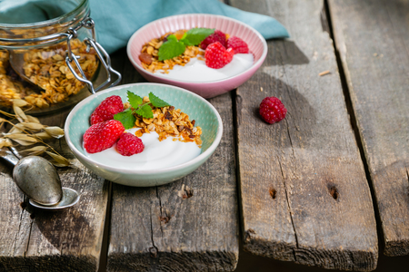 Summer breakfast - granola with strawberries and yogurt, rustic wood background, copy spaceの写真素材