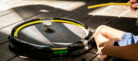 Boys playing beyblades in arena, summer time. Popular game, hype