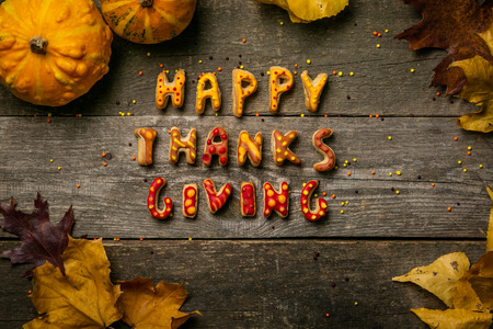 Thanksgiving concept - text with cookies, leaves, pumpkins