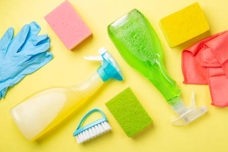Cleaning concept - cleaning supplies on pastel yellow backgroundの写真素材