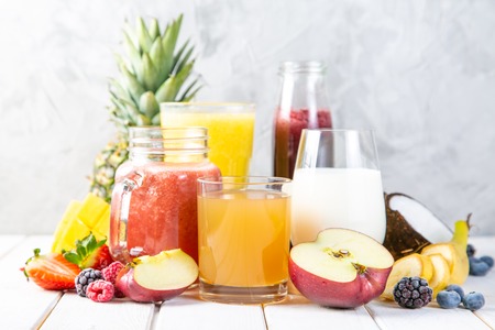Selection of colourful smoothies in glasses with ingredientsの写真素材