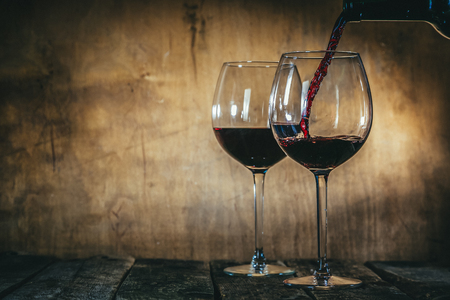 Red wine in glasses on rustic backgroundの写真素材
