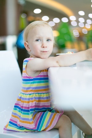 Pretty girl eating ice cream in cafeの写真素材