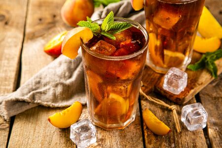Lemon and peach iced tea on wooden backgroundの写真素材