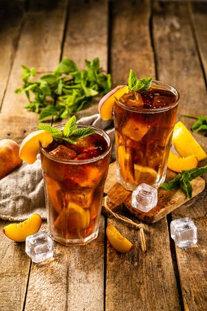Lemon and peach iced tea on wooden backgroundの写真素材