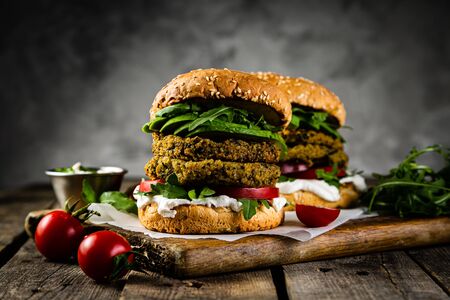 Vegan zucchini burger and ingredients on rustic wood backgroundの写真素材
