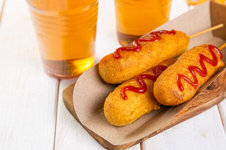 Corn dogs and beer on rustic backgroundの写真素材