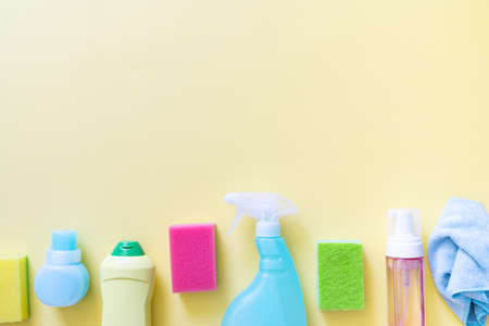Cleaning concept - cleaning supplies on pastel yellow backgroundの写真素材
