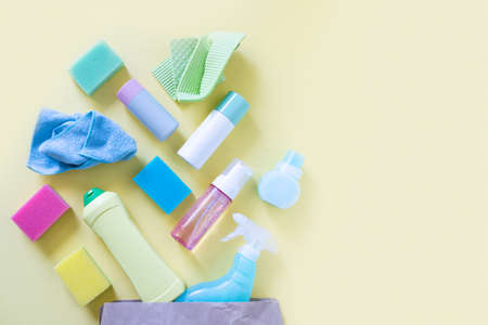 Cleaning concept - cleaning supplies on pastel yellow backgroundの写真素材