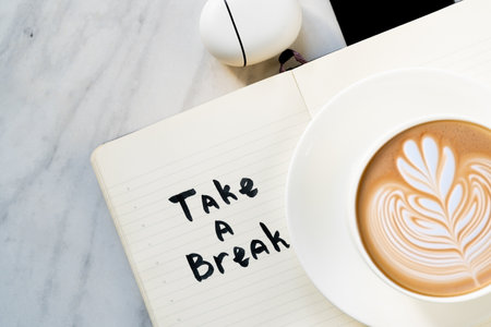 Take a break concept - lettering on notepad, coffee, phone, airphones