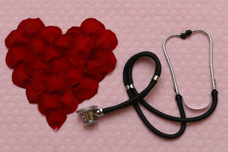 Heart of rose petals and stethoscopeの写真素材