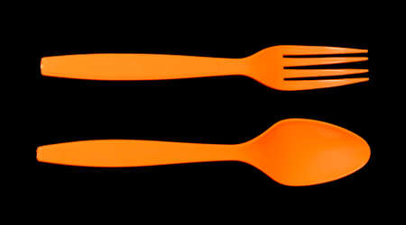 orange fork and spoon isolated on blackの写真素材