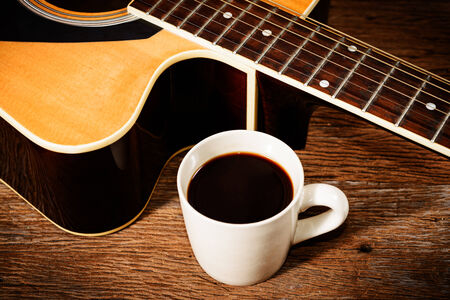 coffee cup and guitar on wooden tableの写真素材